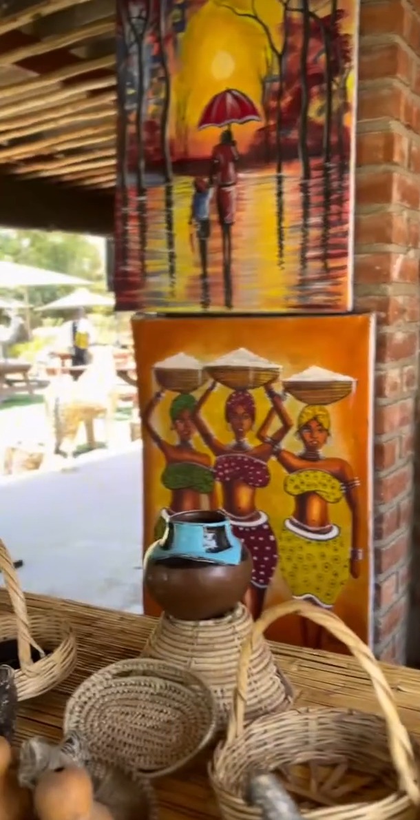 Hand-painted canvases of African women and woven baskets on display