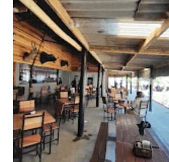 Covered wooden deck seating under a thatched roof