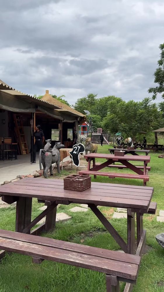 Numbered picnic tables in the garden with camel and cheetah sculptures nearby