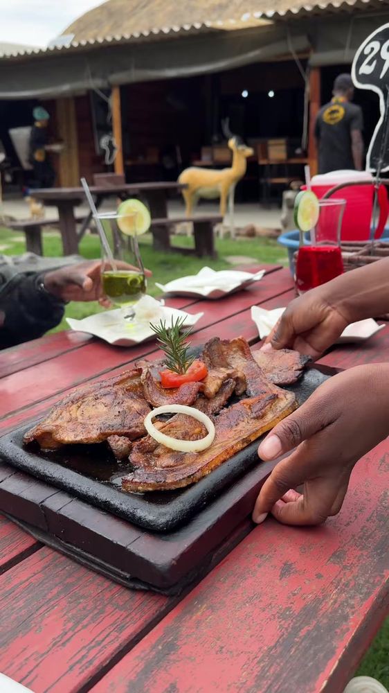 Sizzling grilled pork served on a hot plate with tomato and onion
